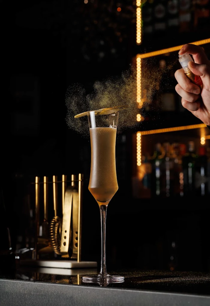 Champagne cocktail being poured at the bar