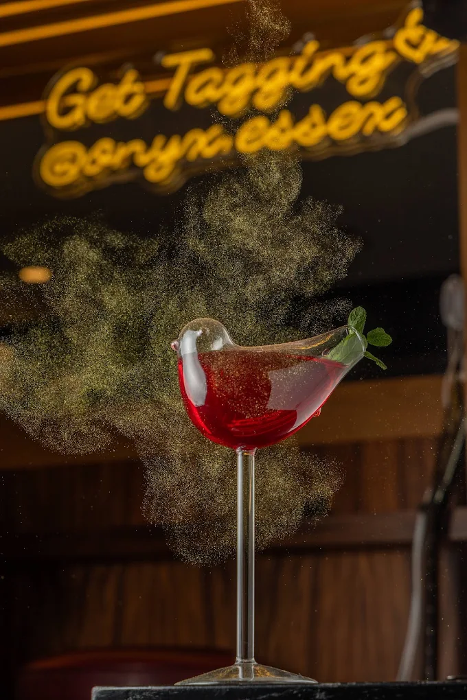 Red cocktail with garnish dusting at Onyx