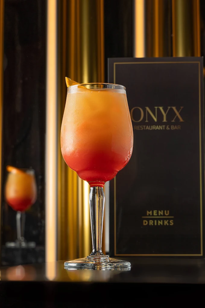 Sunset cocktail beside the Onyx drinks menu
