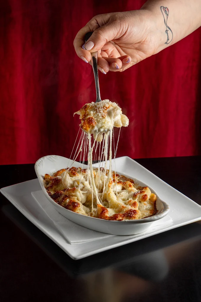 Pasta with melted cheese being lifted
