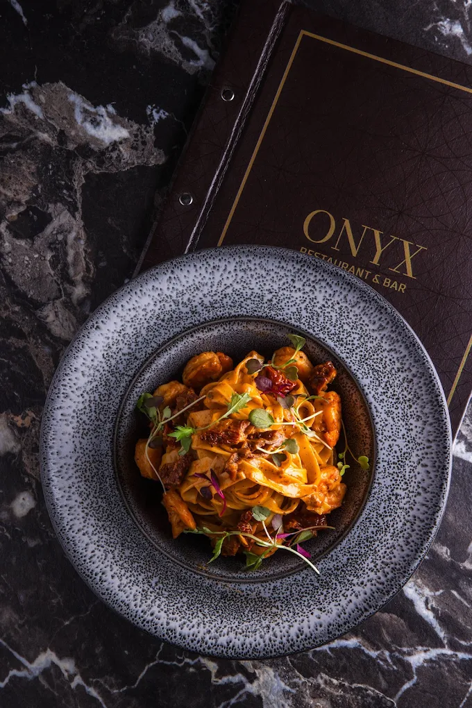Pasta dish served beside the Onyx menu