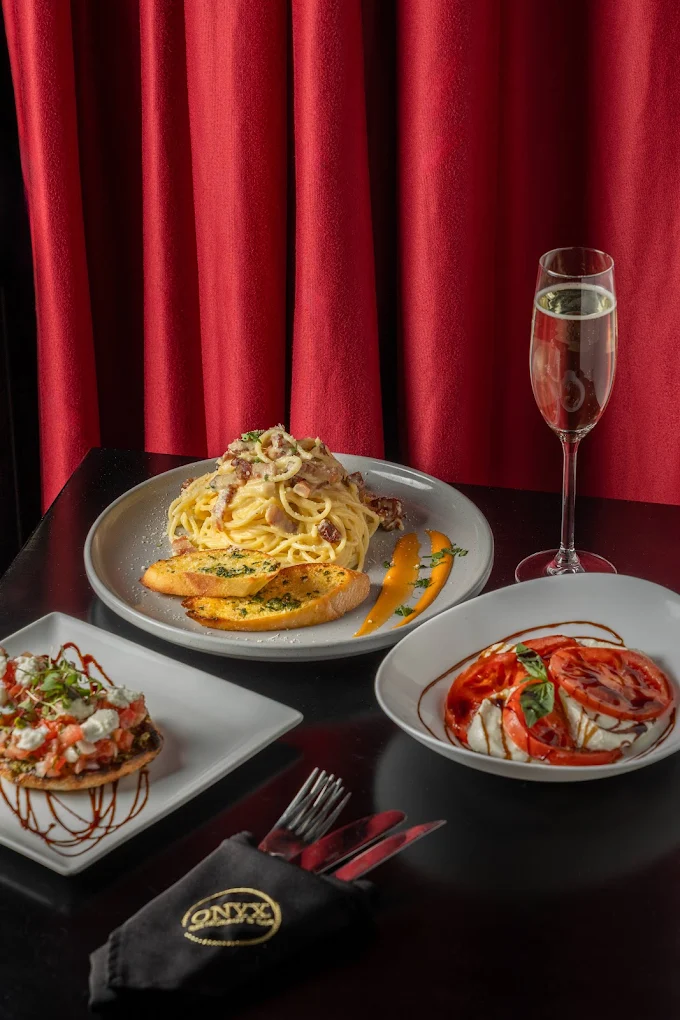 Pasta and drinks spread across an Onyx table