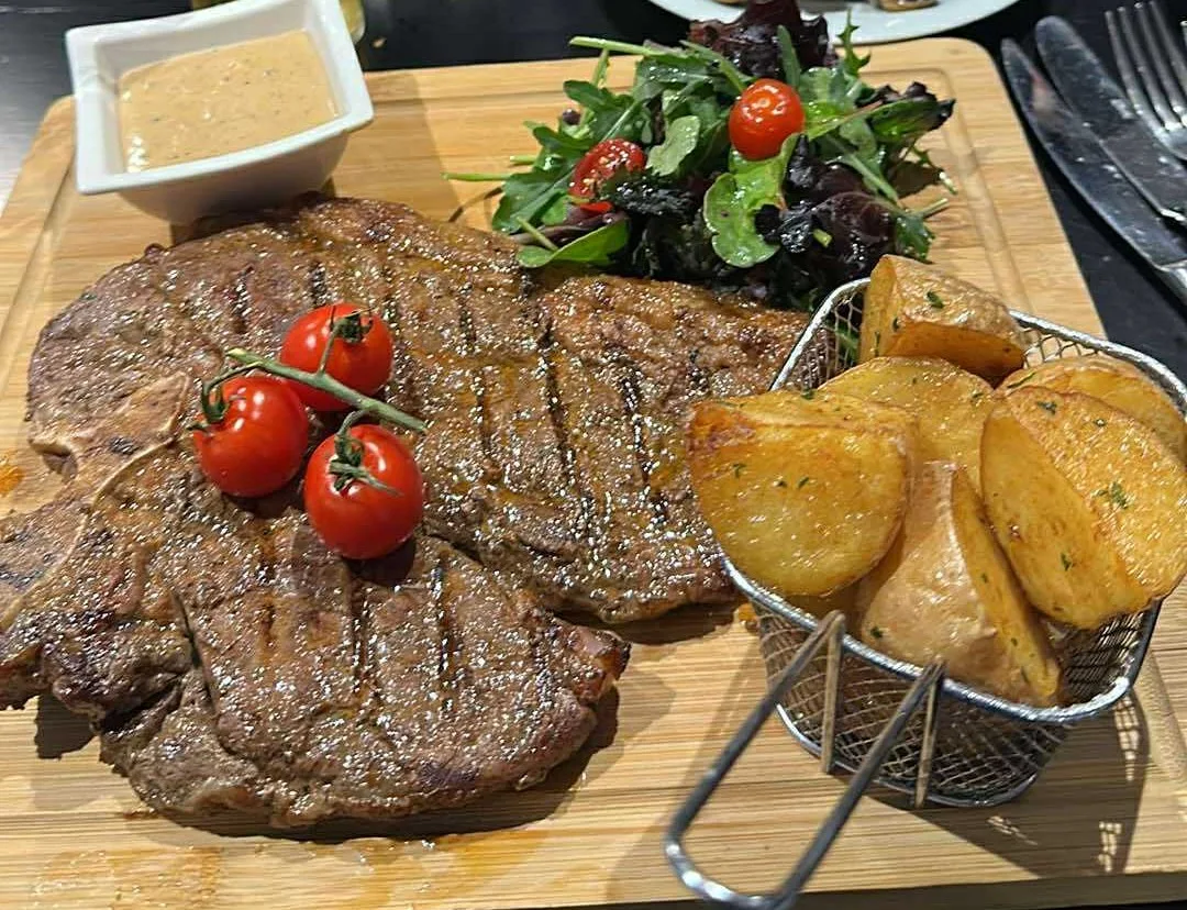 Ribeye steak served on a board with garnish